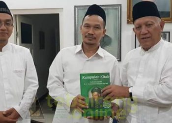 Pengasuh Pesantren Tebuireng KH Abdul Hakim Mahfudz (Gus Kikin) menyerahkan buku tentang Kiai HAsyim ke Gus Baha