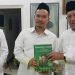 Pengasuh Pesantren Tebuireng KH Abdul Hakim Mahfudz (Gus Kikin) menyerahkan buku tentang Kiai HAsyim ke Gus Baha